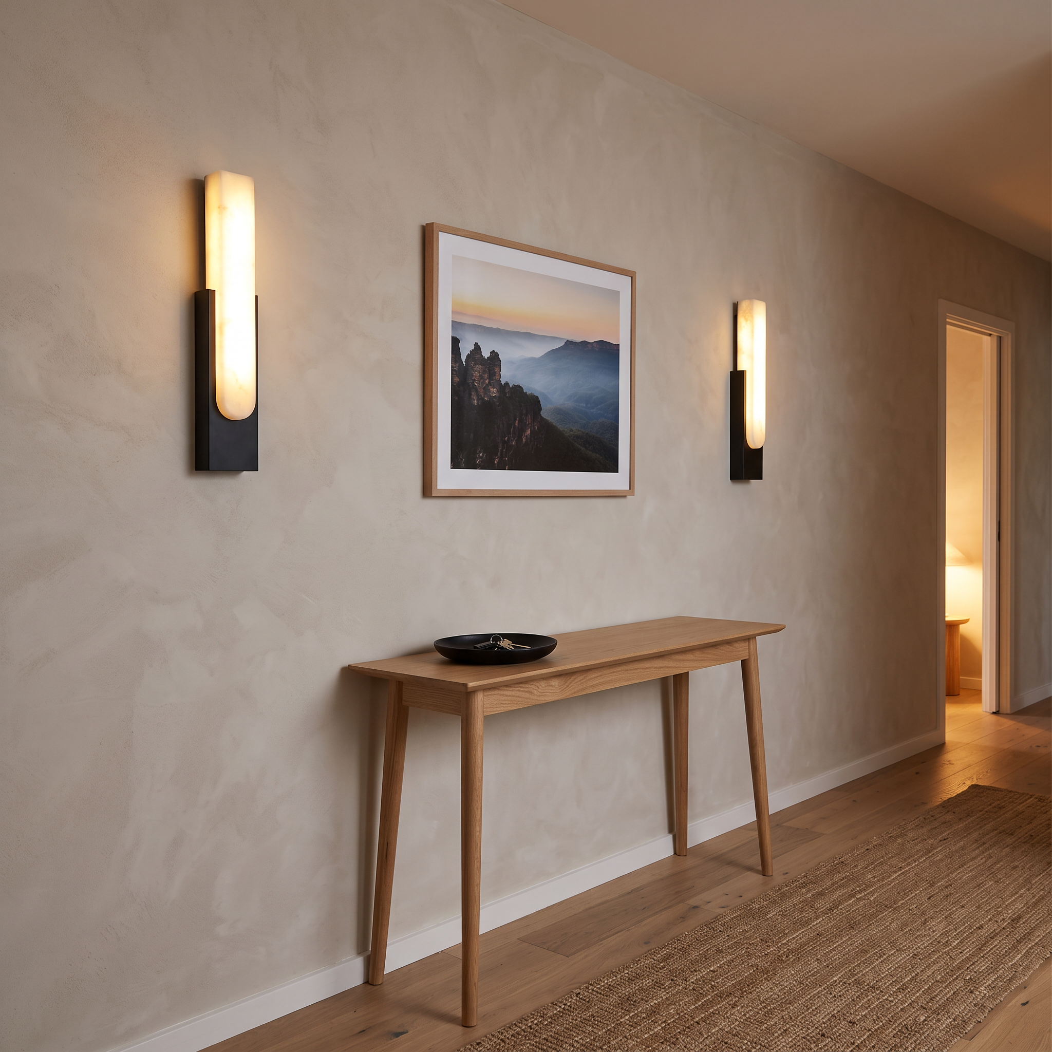 Mali alabaster LED wall sconces in Black along a limewashed hallway above an oak console
