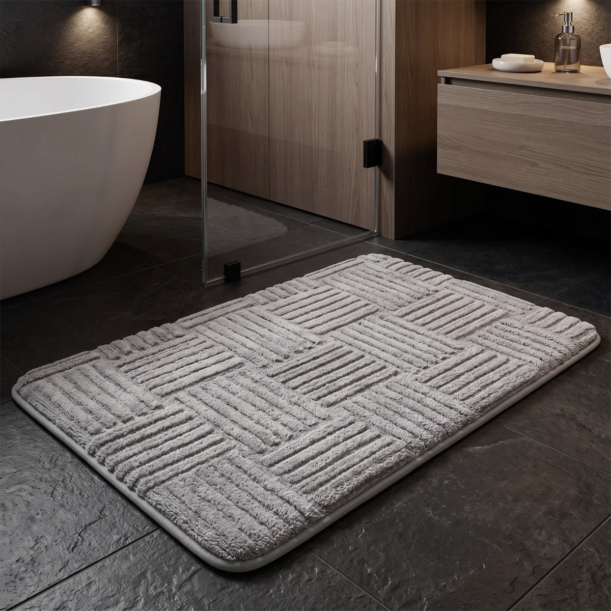 Marden striped non-slip bath mat in light grey in a modern bathroom with a freestanding bath