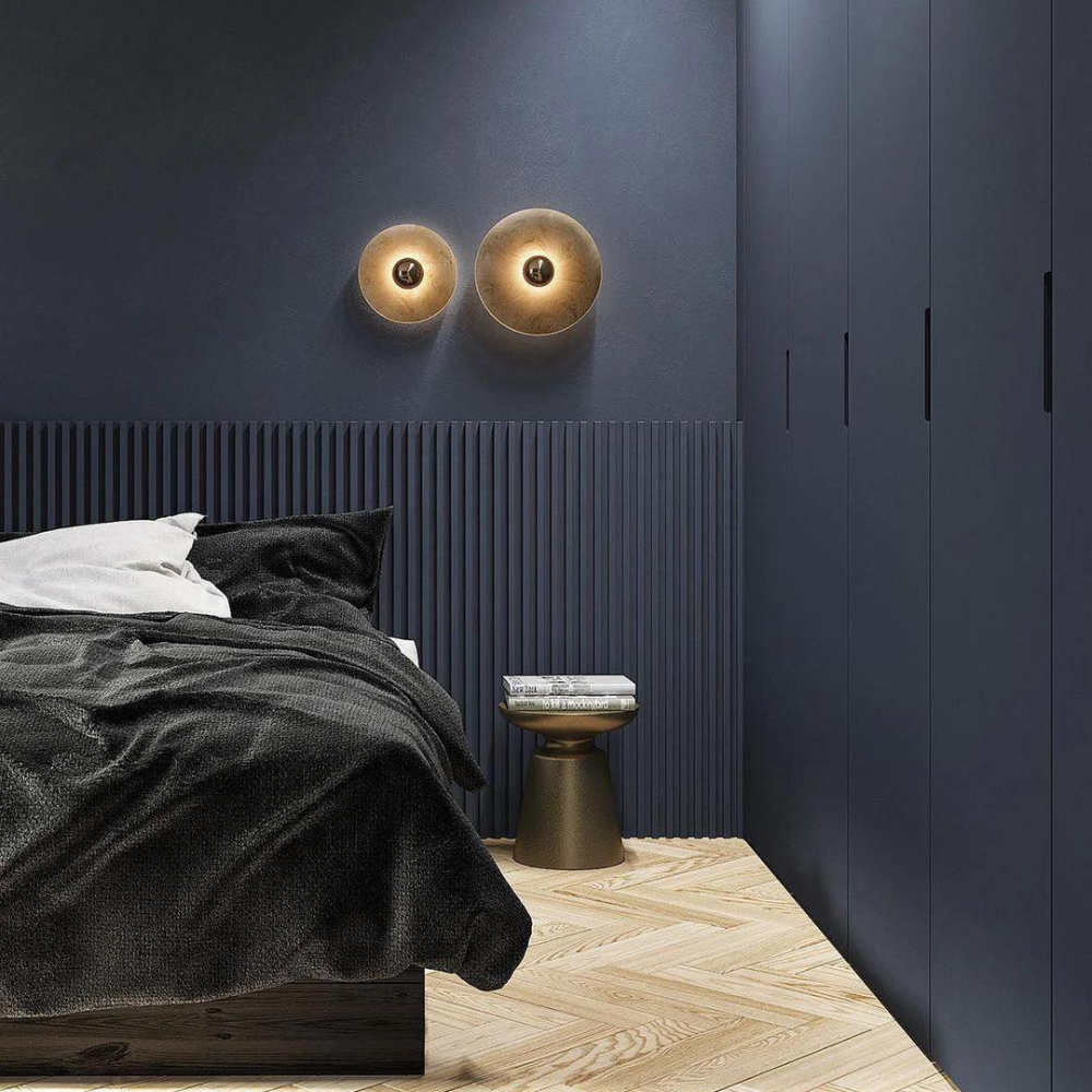 Miki round alabaster wall light glowing warm white against a plain wall
