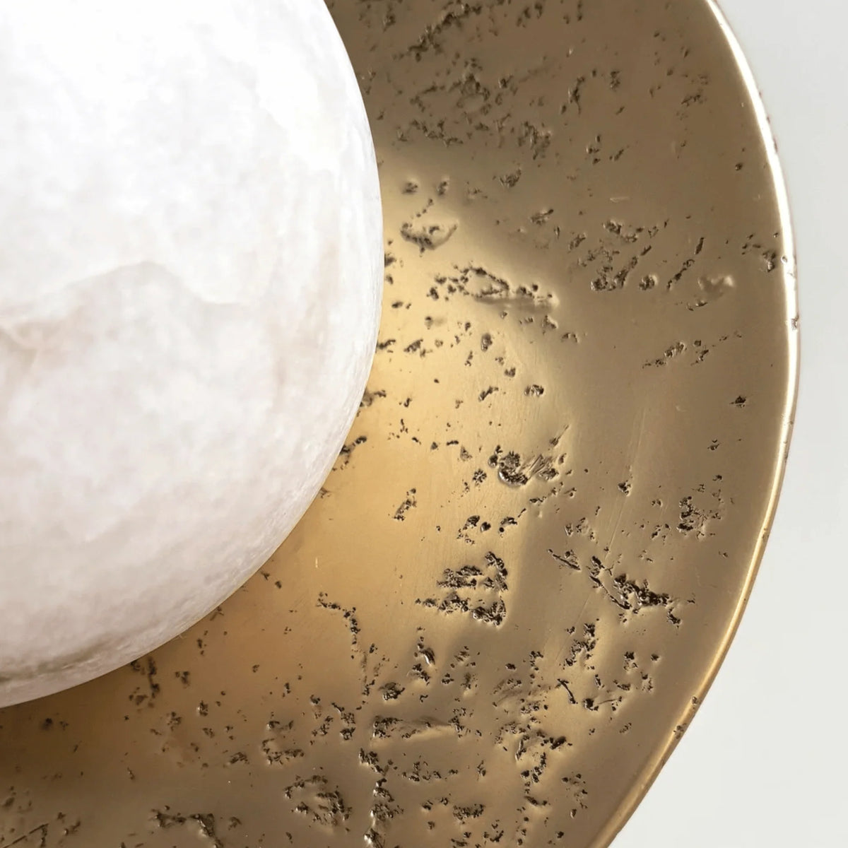 Naomi Art Deco wall sconce close-up of the hammered disc and glowing white sphere
