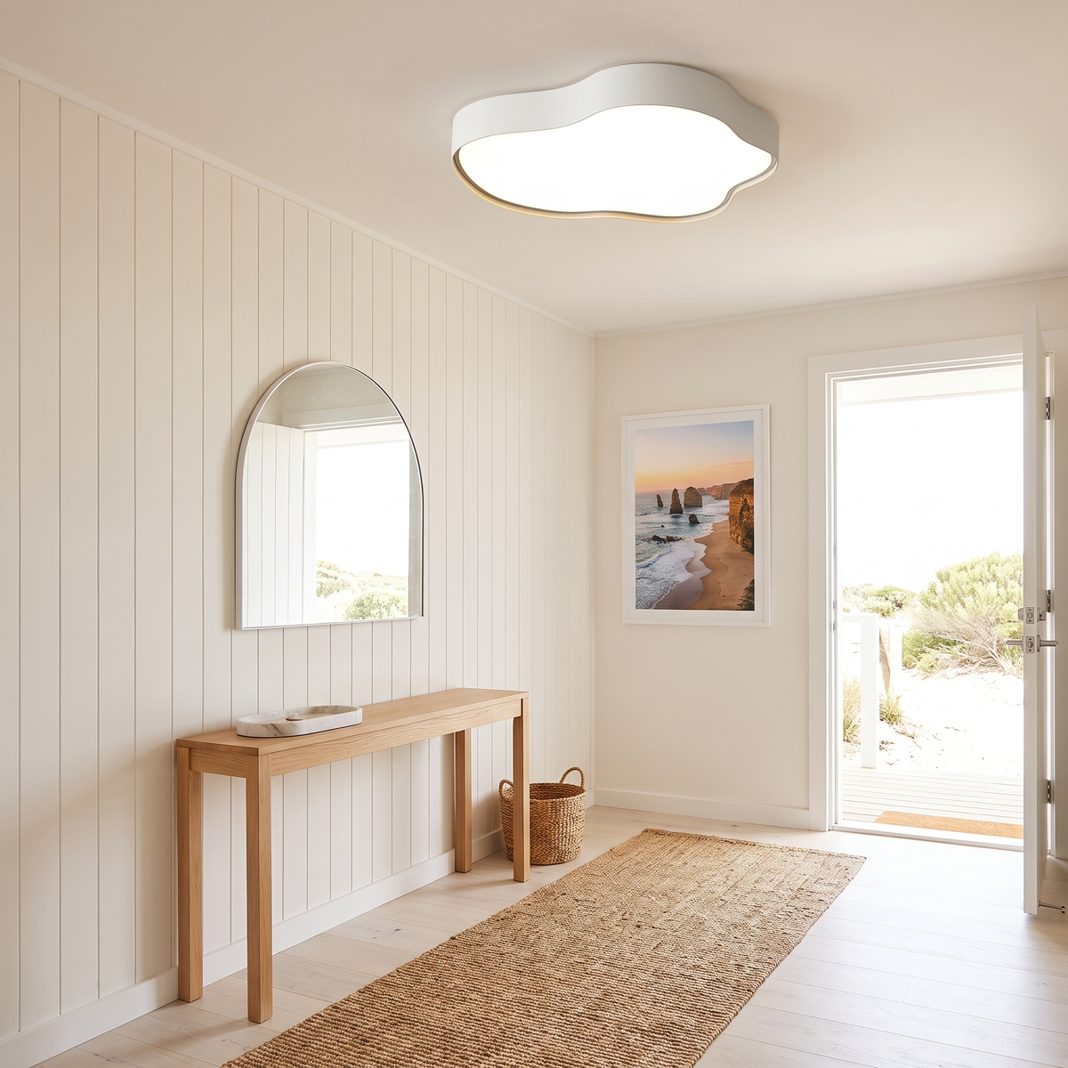 Ness LED cloud ceiling light glowing in a beach house entry hall with white shiplap panelling and a light oak console