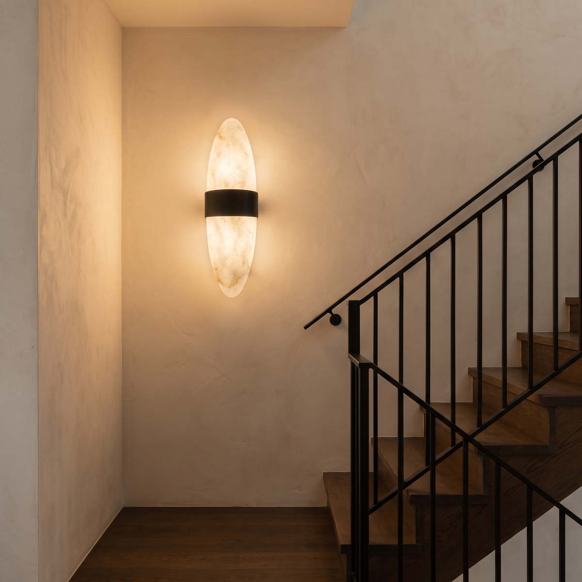 Nula alabaster and black stainless steel wall sconce lighting a stairwell landing