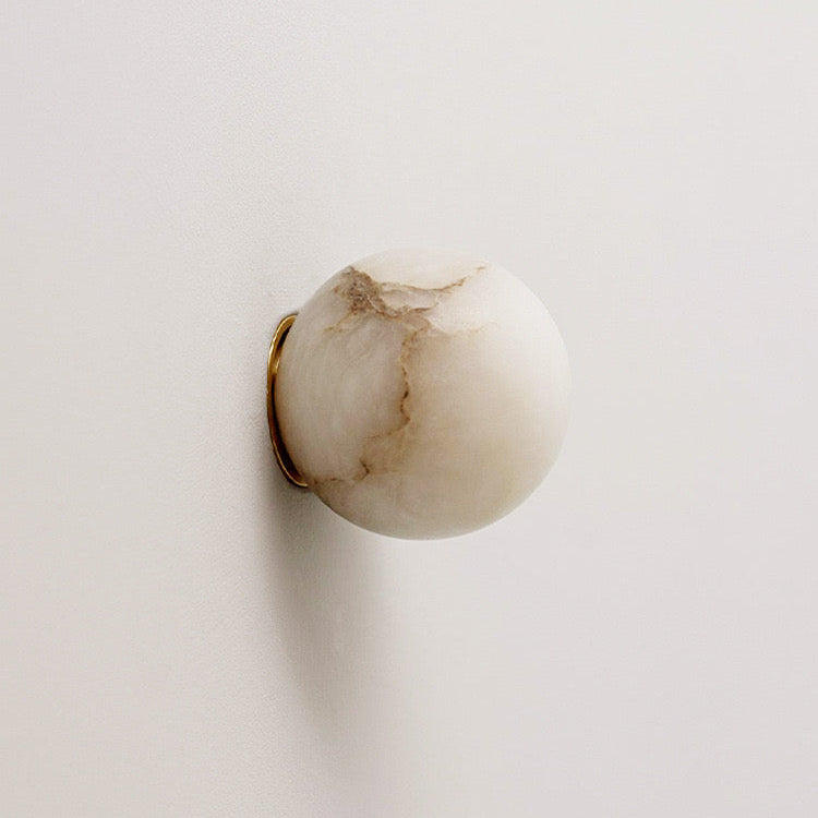 Detail of the spherical carved alabaster shade on the Orby wall lamp