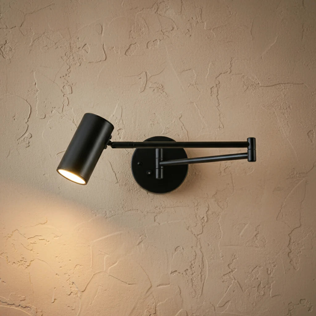 Oren swing arm wall spotlight in black with the folding arm extended on a textured wall