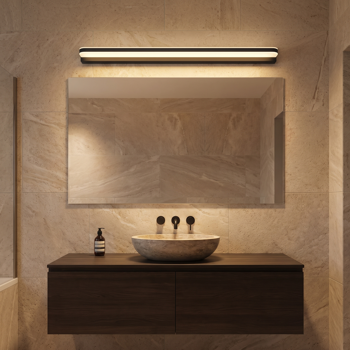 Plata black LED vanity light glowing above a mirror in a travertine and walnut ensuite
