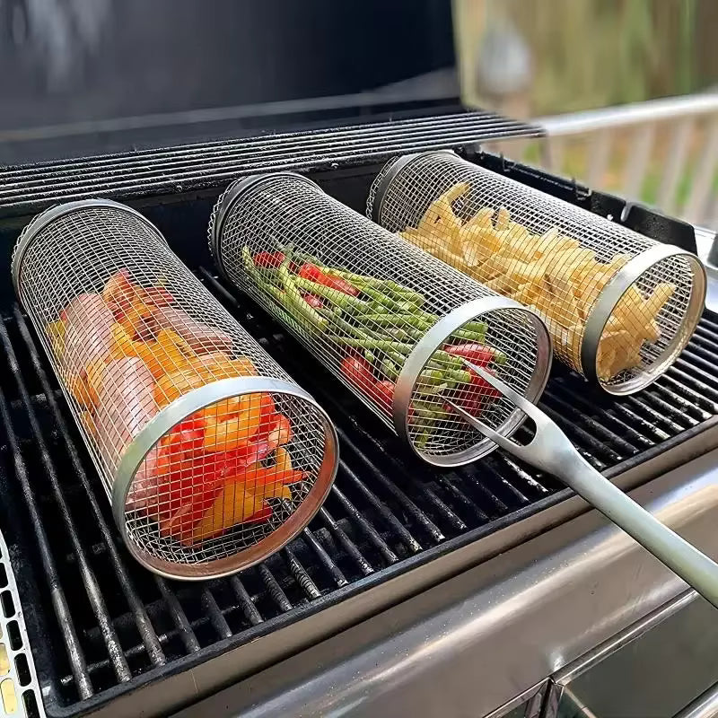 Three Prenta rolling grilling baskets filled with vegetables on a gas BBQ, one turned with a fork