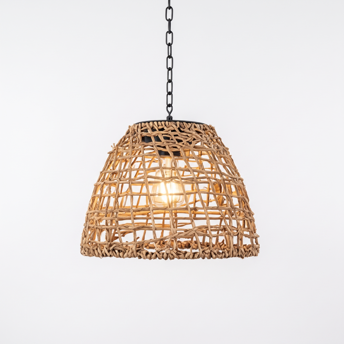 Riley rattan solar lantern, a woven bell shade on a black chain and hook, on a white background