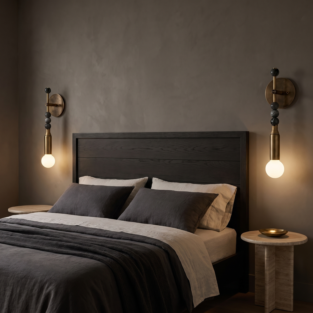 Sands antique brass and black marble wall sconces either side of a dark timber bed