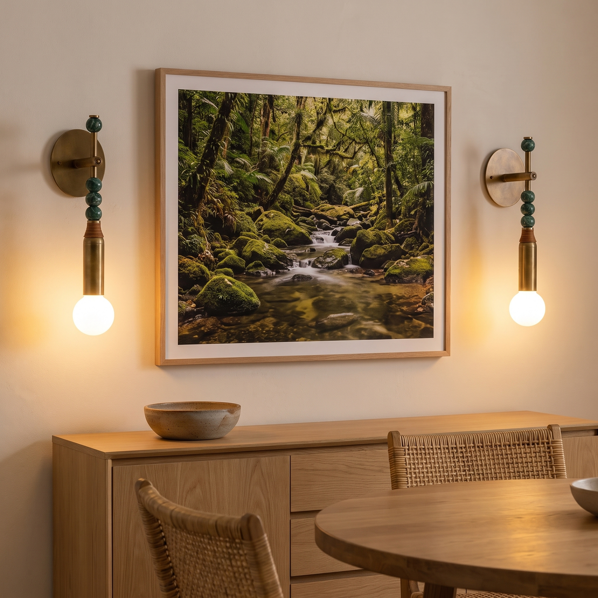 Pair of Sands brass and green marble wall sconces flanking artwork in a dining room