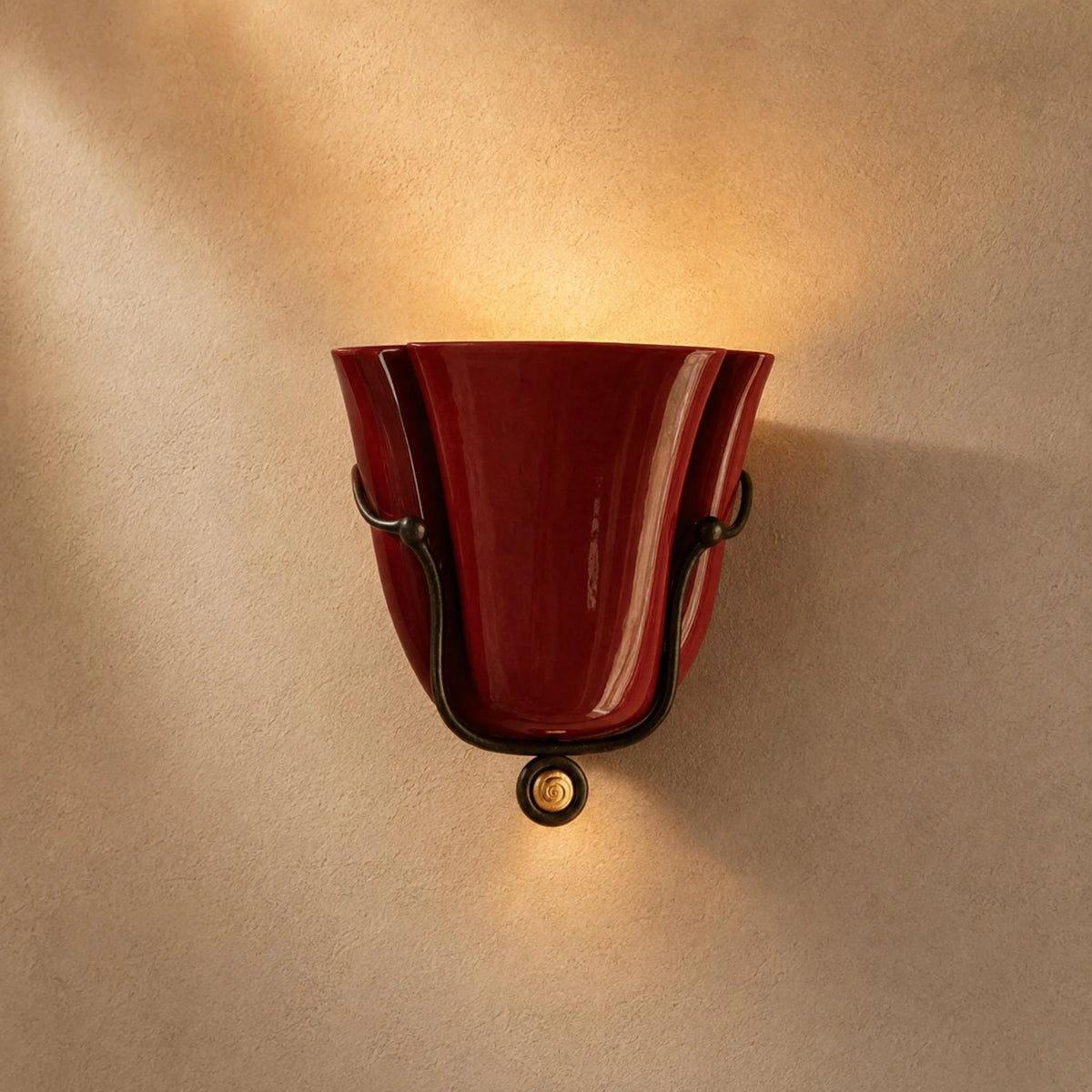 Smyth ceramic wall sconce in glossy burgundy glaze in a black forged cradle