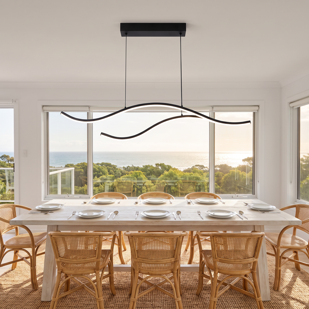 Black Soho wave LED pendant over a coastal dining table set with Dorsia cutlery