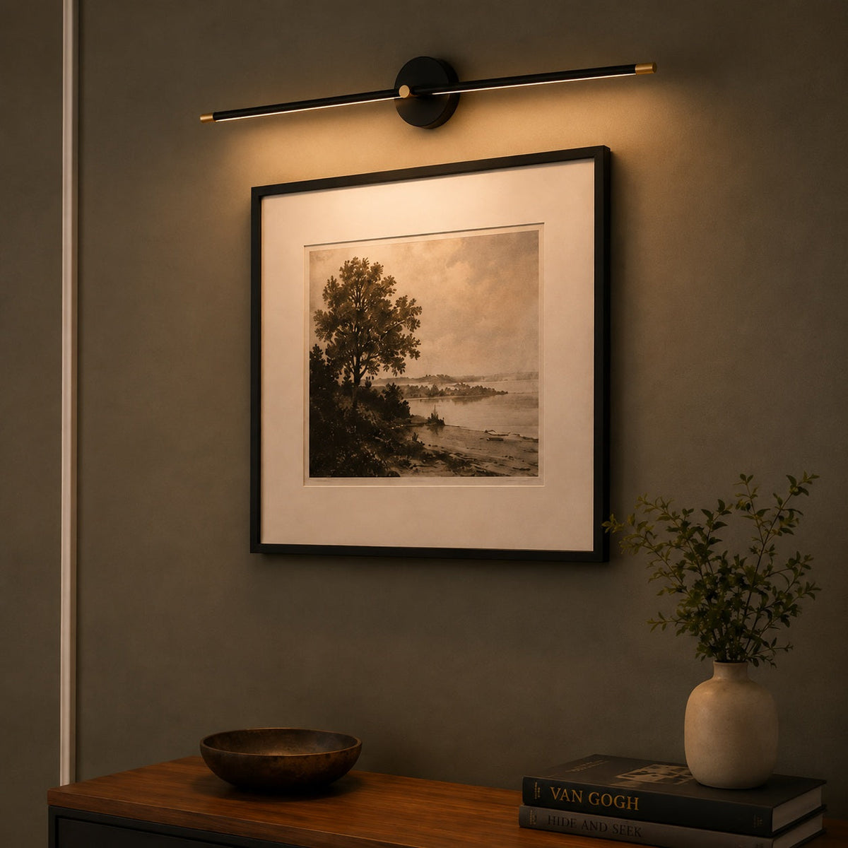 Tomi linear wall sconce in black mounted as a picture light above framed artwork