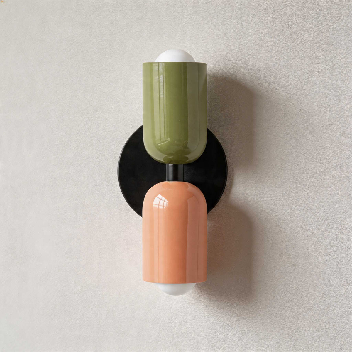 Vic Nordic up down wall sconce with a black wall plate, green upper shade and pink lower shade