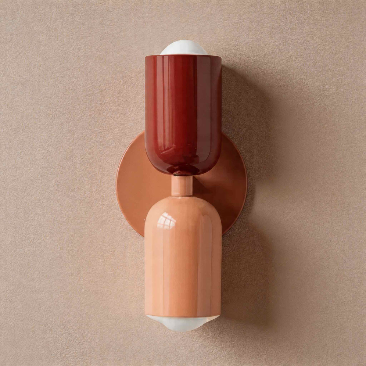 Vic Nordic up down wall sconce with a pink wall plate, red upper shade and pink lower shade