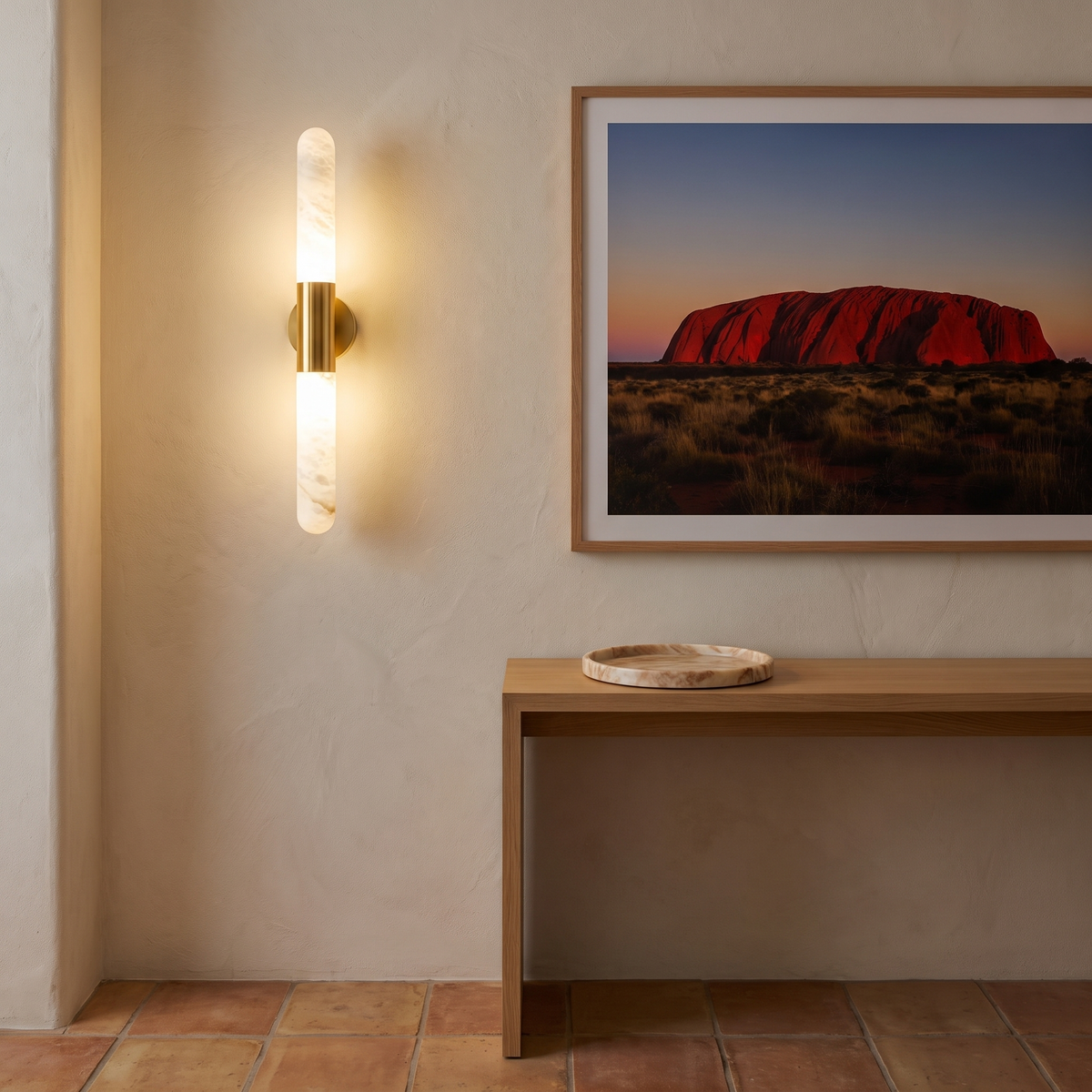 Waverly gold and alabaster wall sconce beside artwork in an entry foyer