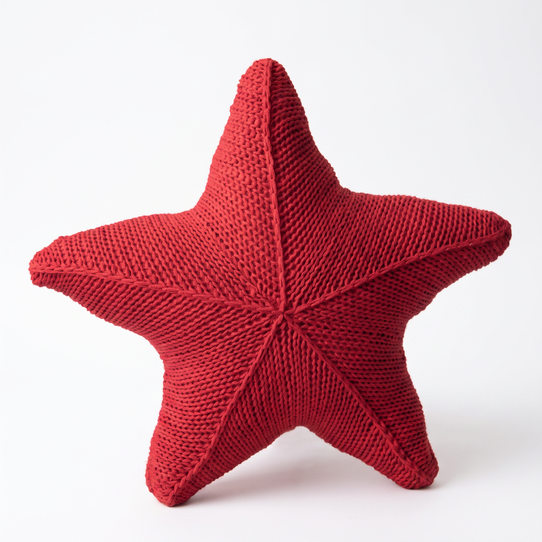 Zoe hand-knitted starfish cushion in Coral Reef on a white background